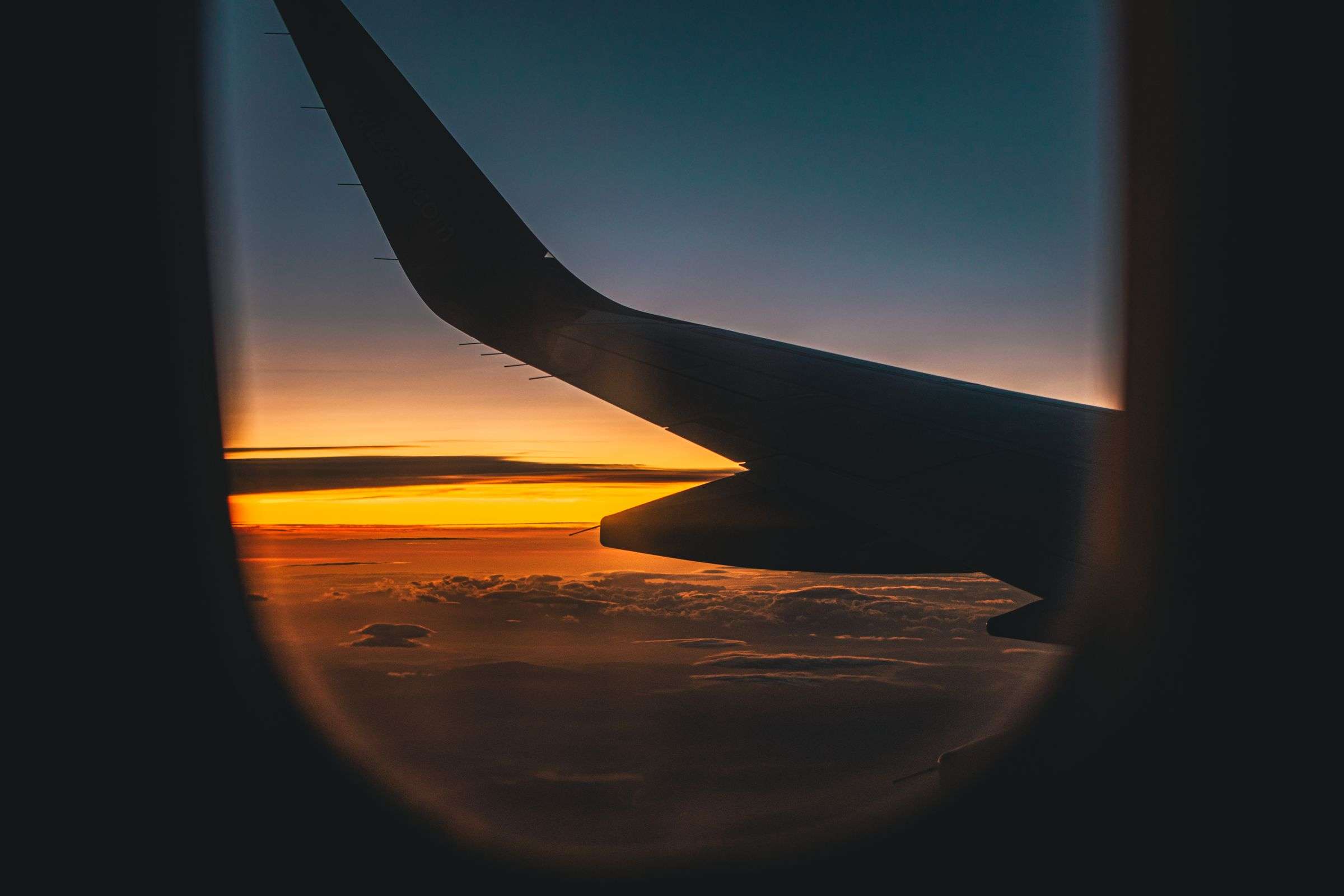 Aircraft wing above the clouds at sunset